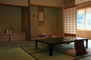 a living room with a table and a window at Arima Onsen Takayamaso Hanano in Kobe