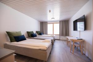 Habitación de hotel con 2 camas y TV en Kisakallion Urheiluopisto, Lohja, en Lohja