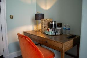 a wooden desk with a chair and a lamp on it at The Clock Face Prescot in Prescot