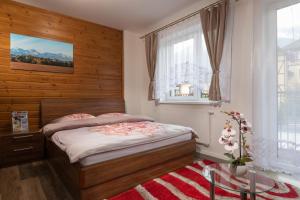 a bedroom with a bed and a window at Tatry Apartman, PRIMO, Starý Smokovec, Vysoké Tatry in Starý Smokovec