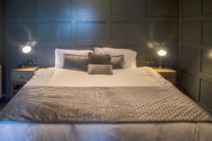 1 dormitorio con 1 cama grande y 2 lámparas en The Clock Face Prescot en Prescot