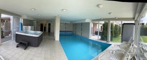 a swimming pool with a tub and chairs in a house at ★ BB Wellness Apartman ★ in Siófok