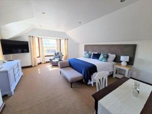 a large bedroom with a large bed and a chair at One Rawdons Estate in Nottingham Road
