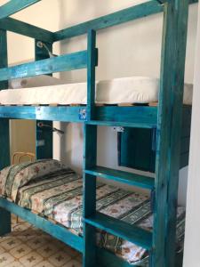 two bunk beds in a room with a bed at Hostel Beach House in Giardini Naxos