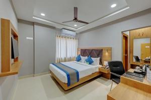 a bedroom with a bed and a desk and a mirror at Click Hotel Guwahati in Guwahati