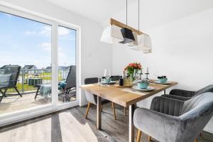a dining room with a table and chairs and a balcony at FeWo Olpenitz in Olpenitz