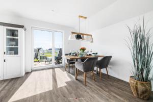 a white dining room with a table and chairs at FeWo Olpenitz in Olpenitz +26 photos