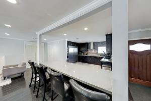 a kitchen with a large white counter and chairs at Shoshone Dream in Van Nuys