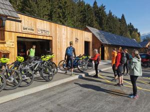 a group of people standing outside of a building with bikes at Ribno Luxury Glamping in Bled