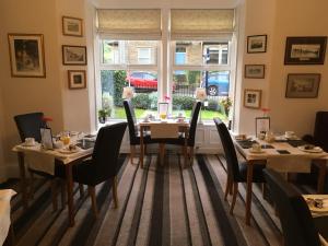 a dining room with tables and chairs and a window at Ebor House in Hawes