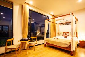 a bedroom with a canopy bed and a table and chairs at Blue Sea Hotel in Dali