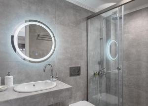 een badkamer met een douche, een wastafel en een spiegel bij Athenian Spirit in Athene
