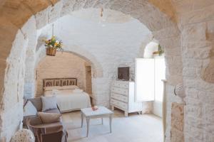 um quarto com uma cama e uma mesa num quarto em Trullo La Dama Forestiera em Alberobello