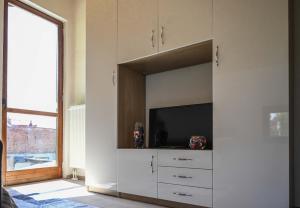 a large white cabinet with a television in it at Elem apartmani Skver in Tuzla