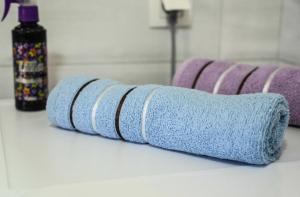 a row of purple and blue towels on a counter at Elem apartmani Skver in Tuzla +18 photos