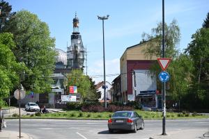 a car is driving down a city street at Elem apartmani Skver in Tuzla
