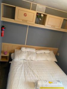 a bedroom with a bed with white sheets and cabinets at 187 sealands in Ingoldmells