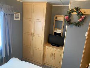 a bedroom with a bed and a tv on a shelf at 187 sealands in Ingoldmells