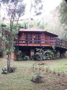 une grande maison en bois au milieu d'une cour dans l'établissement CASA EM MONTE VERDE CHARME E CONFORTO, à Monte Verde