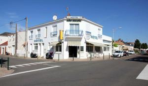 un edificio blanco en la esquina de una calle en Hotel le Bon Soleil, en Les Sables-dʼOlonne