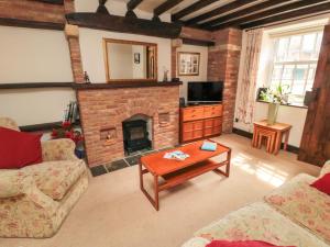 a living room with a brick fireplace and a table at Pegasus Cottage in Whitby