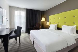 a hotel room with a large white bed and a desk at Radisson Blu Sobieski in Warsaw
