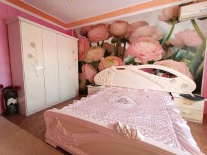 a bedroom with a bed with pink flowers on the wall at Шевченко 1 in Kropyvnytskyi