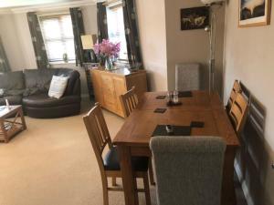 sala de estar con mesa de madera y sillas en Captivating Apartment in Copthorne near Gatwick, en Copthorne