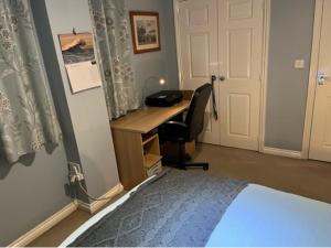 1 dormitorio con escritorio, 1 cama y escritorio en Captivating Apartment in Copthorne near Gatwick, en Copthorne