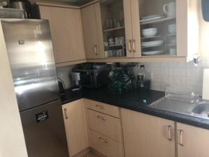 cocina con nevera de acero inoxidable y fregadero en Captivating Apartment in Copthorne near Gatwick, en Copthorne