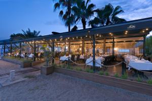 a restaurant with tables and chairs in front of a building at Alaaddin Beach Hotel - Adult Only in Alanya