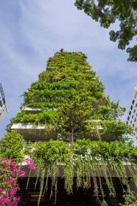 a tree on the side of a building with flowers at Chicland Danang Beach Hotel in Da Nang