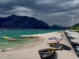 una playa con dos kayaks en ella con barcos en ella en Hotel Europa, en Malcesine
