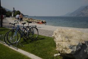 two bikes parked next to a rock next to the water at Hotel Europa in Malcesine