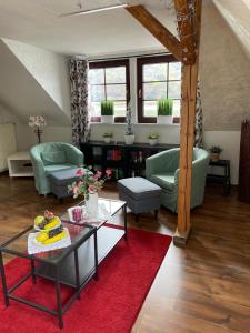 a living room with a table and a red rug at Villa Christina in Kamp-Bornhofen