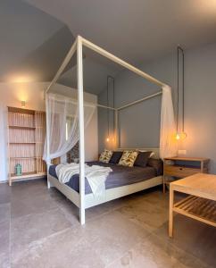 a bedroom with a canopy bed in a room at B&B Sole Mare Luna in Lu Lioni