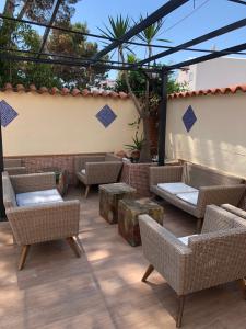 a patio with wicker chairs and tables on a patio at El Cortijo Escana in Es Cana