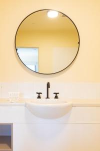lavabo en el baño con espejo grande en la pared en Selina Brisbane, en Brisbane