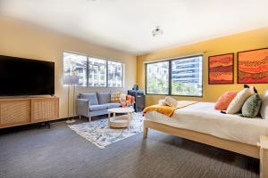 a bedroom with a bed and a flat screen tv at Selina Brisbane in Brisbane