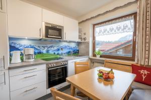 a kitchen with a table with a bowl of fruit on it at Gästehaus Baumgartner in Oberstdorf