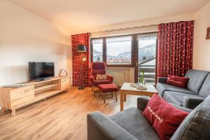 a living room with a couch and a television at Gästehaus Baumgartner in Oberstdorf