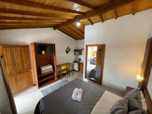 a room with a bed and a television with a towel at Suites Hencke Haus in Canela
