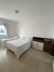 a bedroom with two beds and a television in it at Casa em Condomínio, Aquiraz - CE in Aquiraz +11 photos