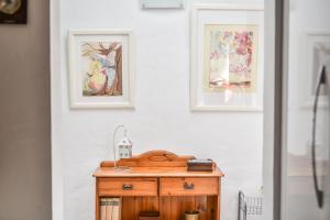 una mesa de madera en una habitación con 3 cuadros en la pared en Casa Tamai, ideal para familias en el centro de la isla en Teguise