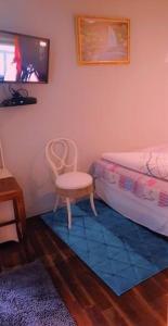a bedroom with a bed and a chair and a rug at Bedfort Accommodation in Cape Town