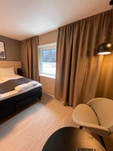Habitación de hotel con cama y ventana en Mosjøen Hotel, en Mosjøen