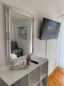 a white dressing table with a mirror and a tv at Apartmani Milkovic in Tučepi