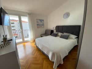 a bedroom with a large bed and a balcony at Apartmani Milkovic in Tučepi