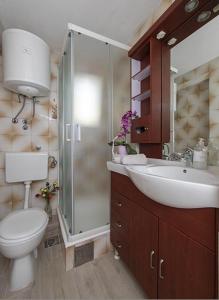 a bathroom with a toilet and a sink and a shower at Apartmani Milkovic in Tučepi +77 photos