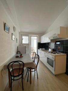 a kitchen with a table and chairs in a room at Apartmani Milkovic in Tučepi